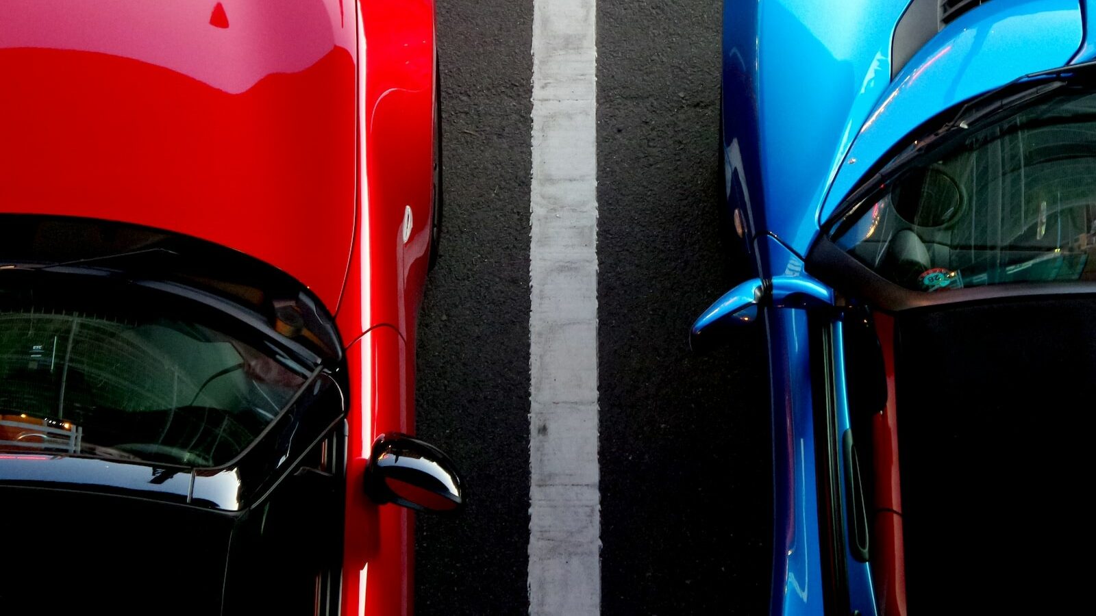 top view photo of red and blue convertibles on asphalt road