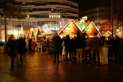 a group of people standing around a christmas market