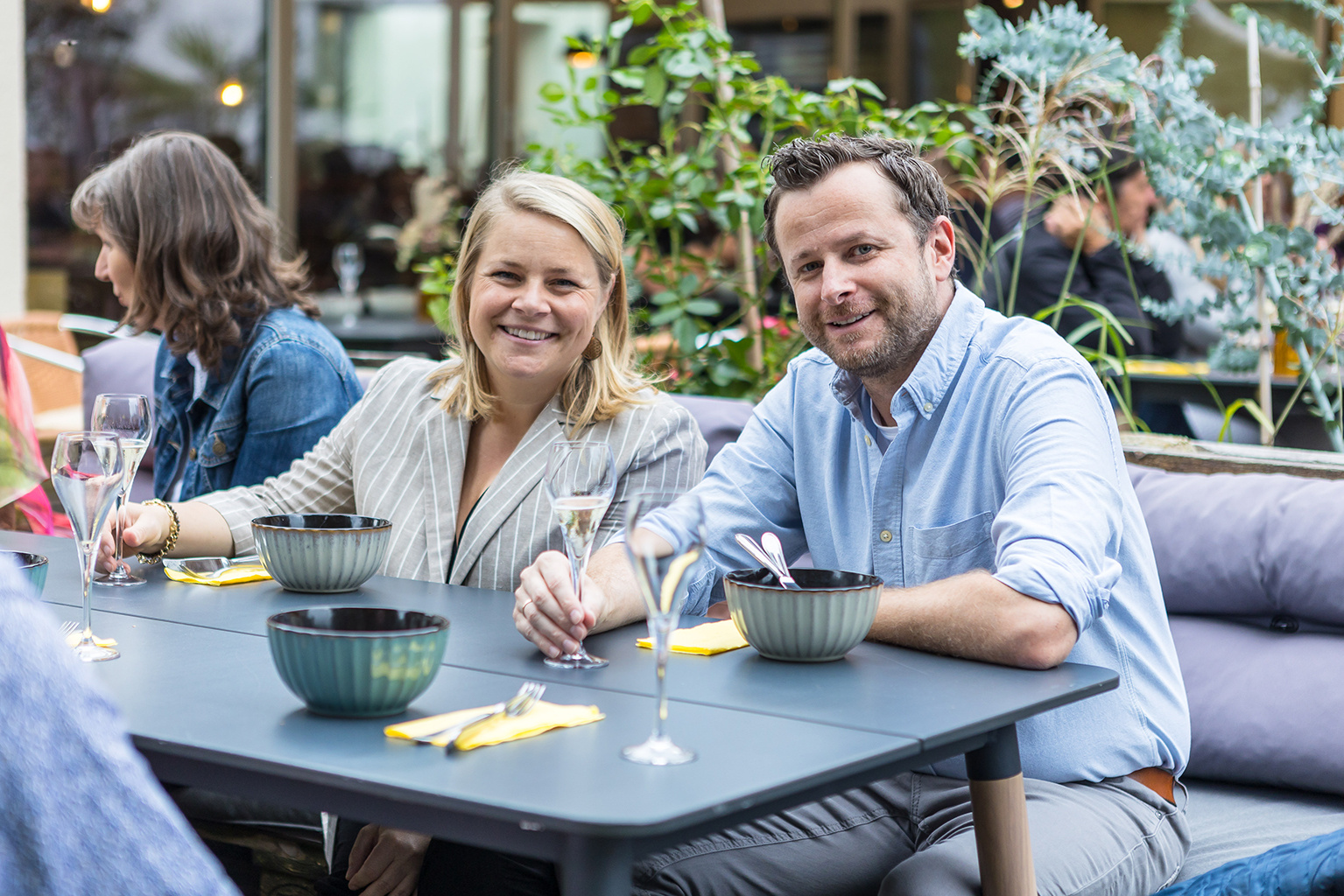 Eine Frau und ein Mann sitzen an einem Tisch und lächeln in die Kamera