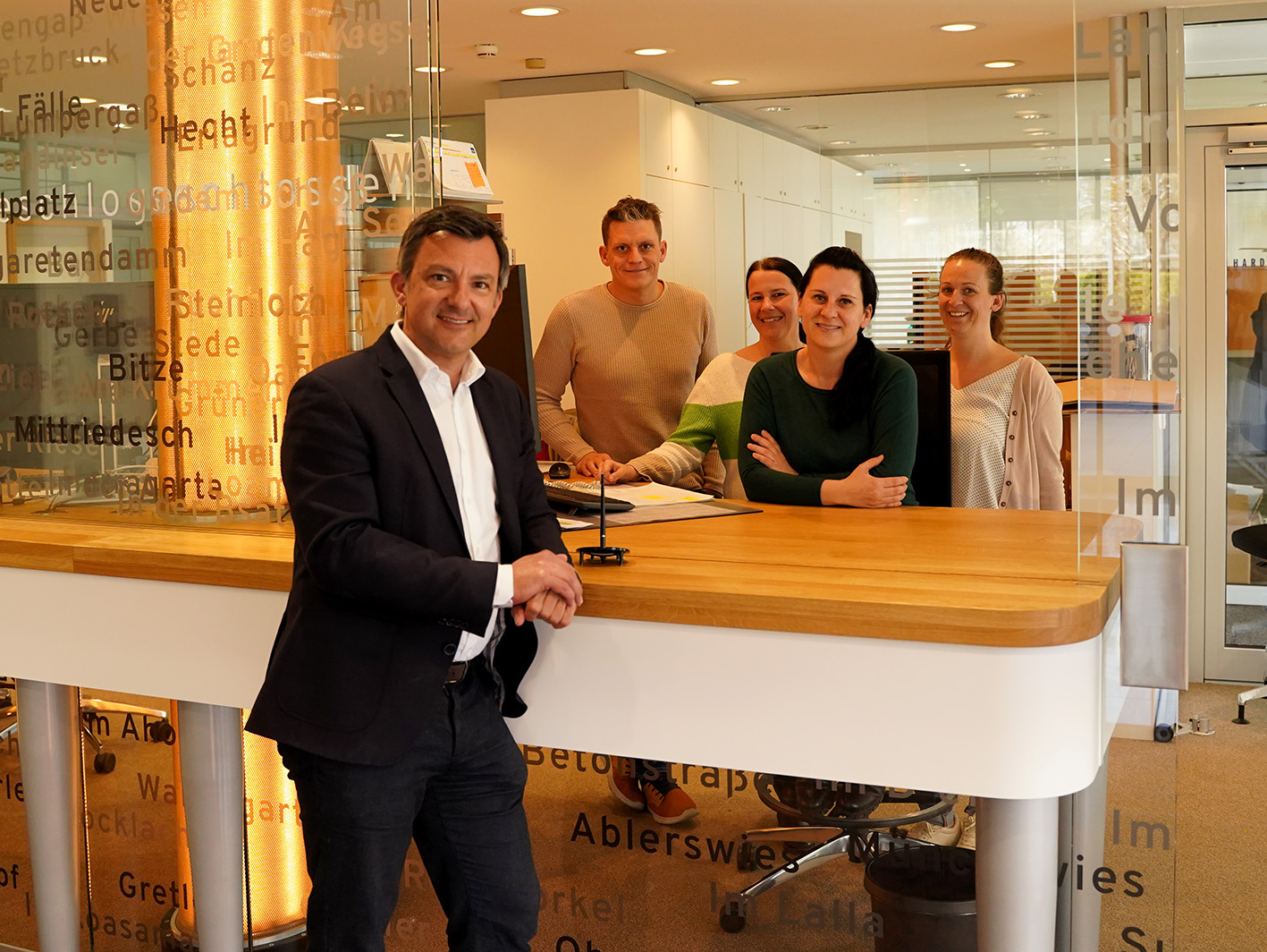 Bürgermeister Staudinger und das Team der Abteilung Bürgerservice & Soziales lächelnd in der neuen Infostelle