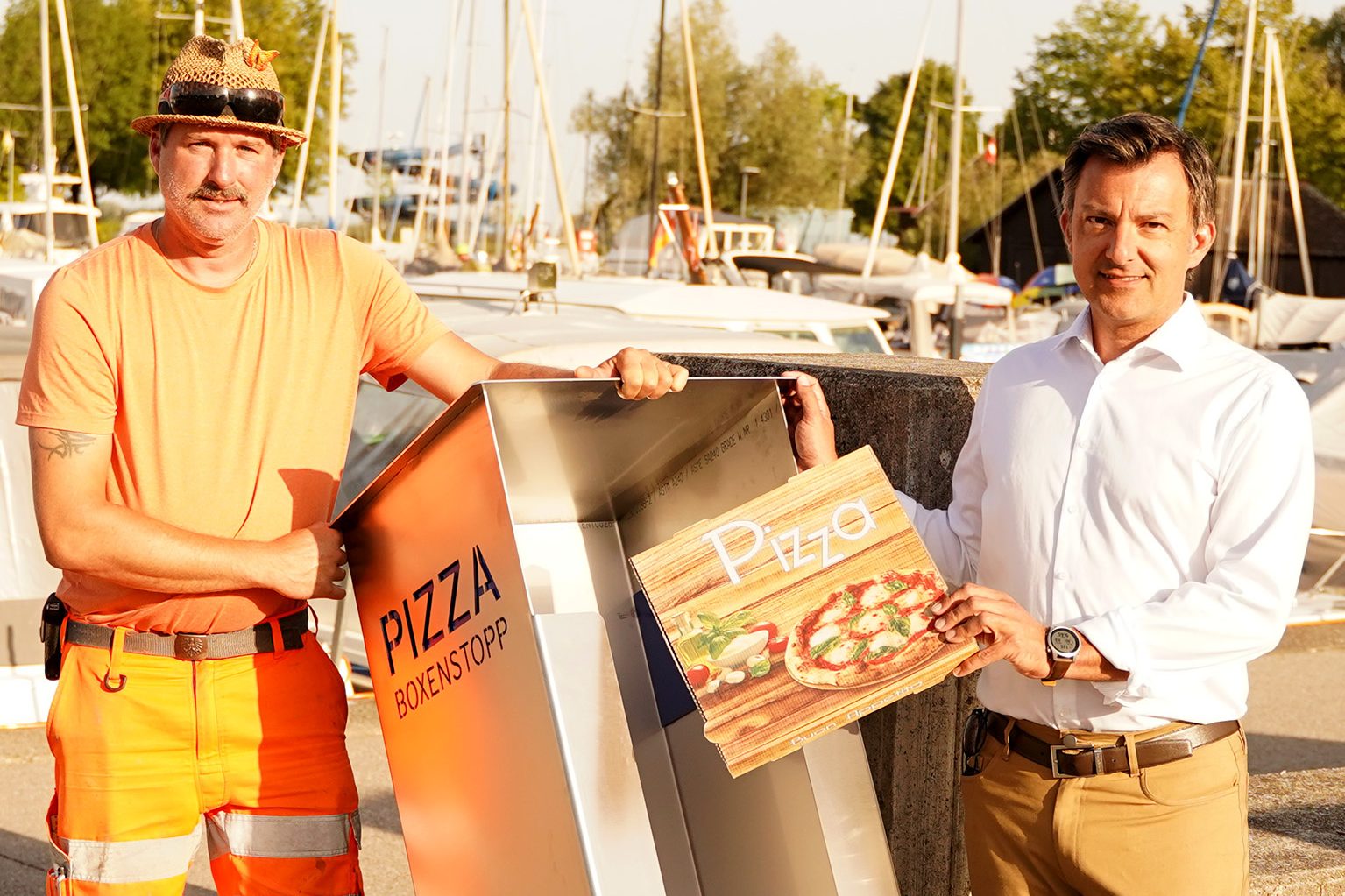 Bürgermeister Staudinger und ein Bauhofmitarbeiter beim Aufstellen einer neuen Pizzasammelstelle