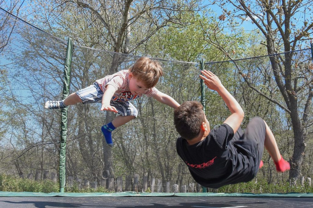 Zwei Kinder hüpfen auf einem Trampolin