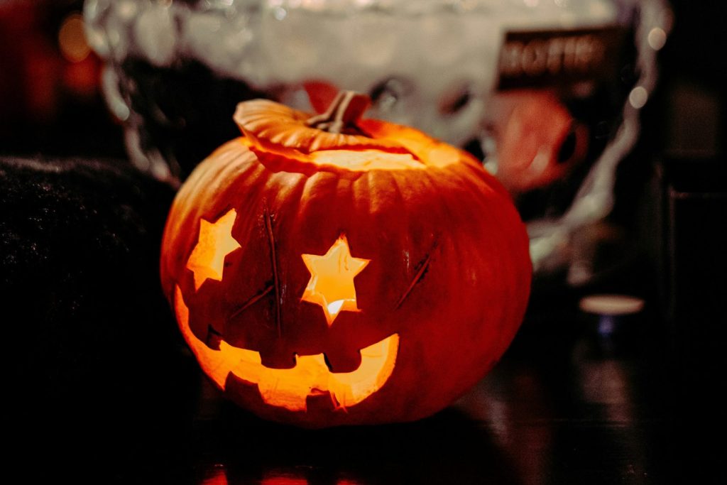 Halloweenkürbis vor einer Glasschale mit Eiswürfeln