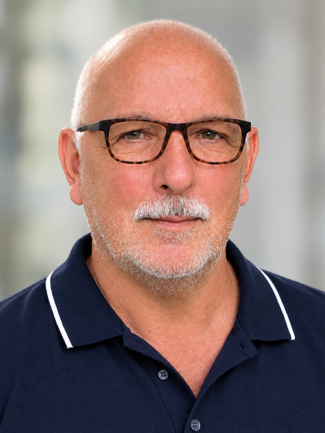 Porträtfoto von Roman Fitz mit Brille und blauem Poloshirt